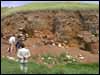 Mr Ahmet Koçak, Aydincik Belediye Baskan, looks on while Mevlüt Üyümez and Geoffrey Summers examine the stratigraphy of the uppermost burnt level.